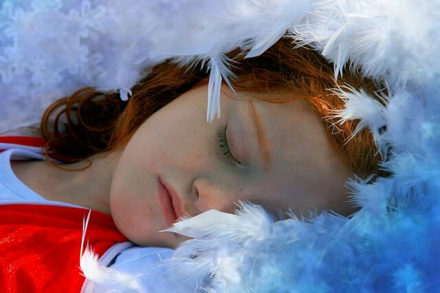Dziewczynka śpiąca wśród piór