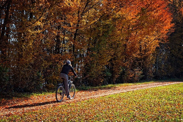 Kobieta jadąca jesienią na rowerze