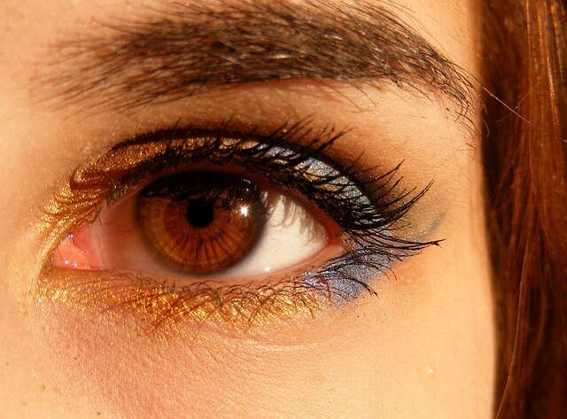 Oko rozświetlone złoto-fioletowym cieniem